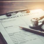 health insurance claim form with stethoscope on wood table selective focus