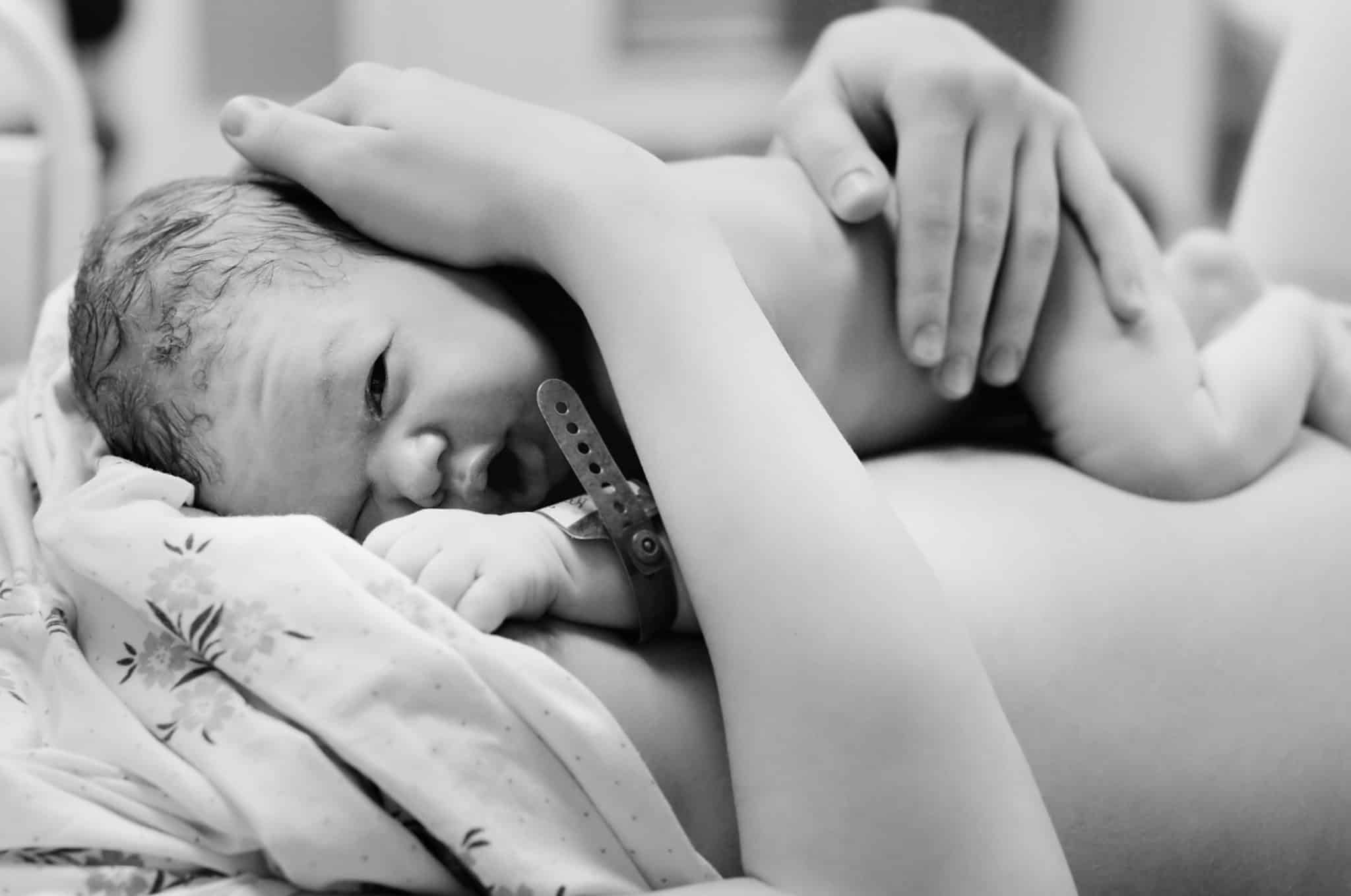 Black and white shot of newborn baby right after delivery